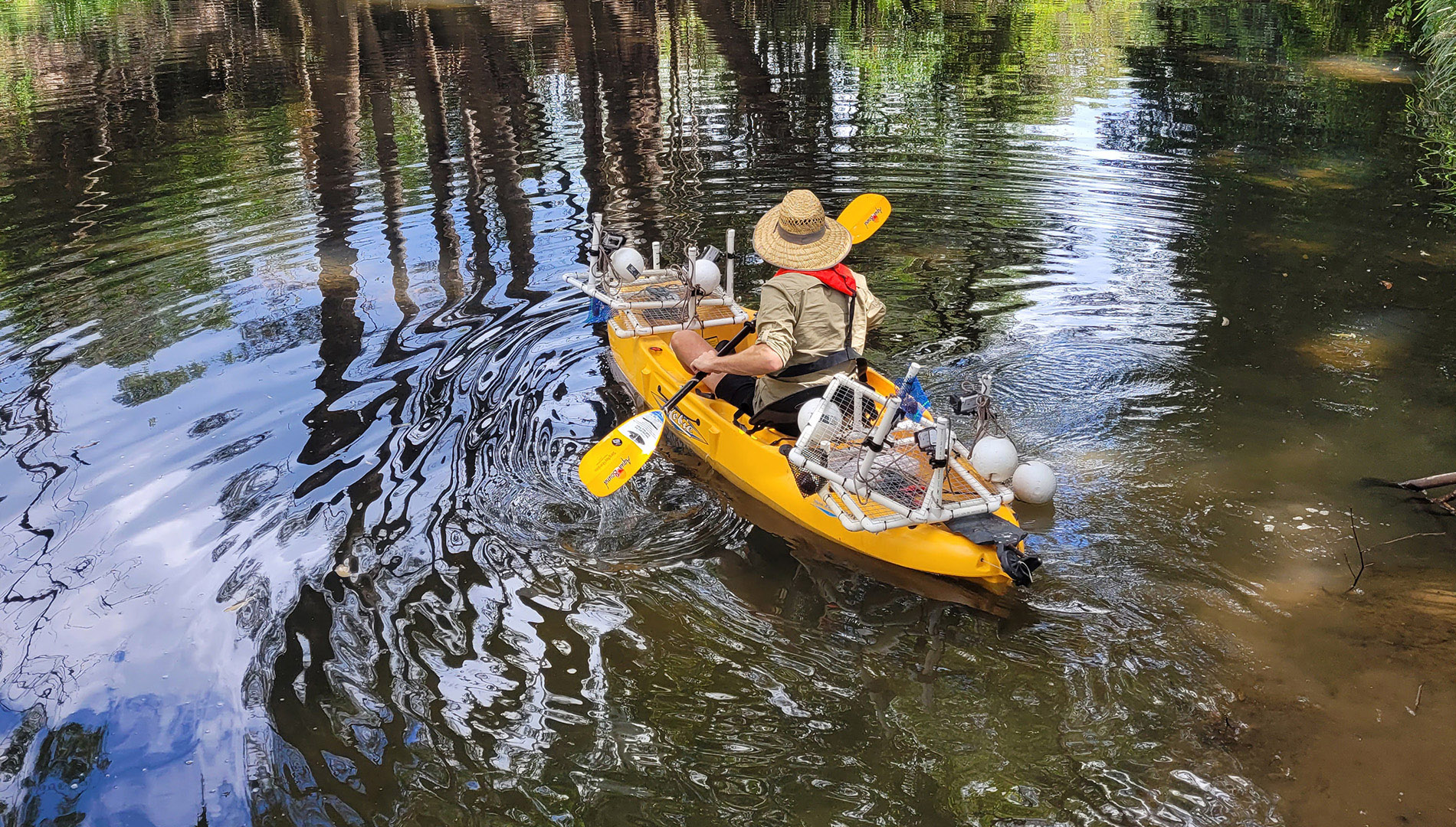 DPE scientists use a kayak to deploy the Baited Remote Underwater Video (BRUV) into the middle of a pool within the river channel.