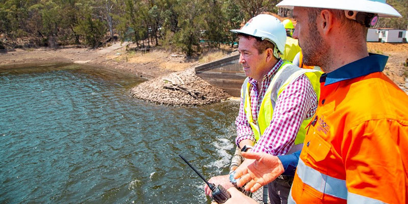 Two men surveying dam water